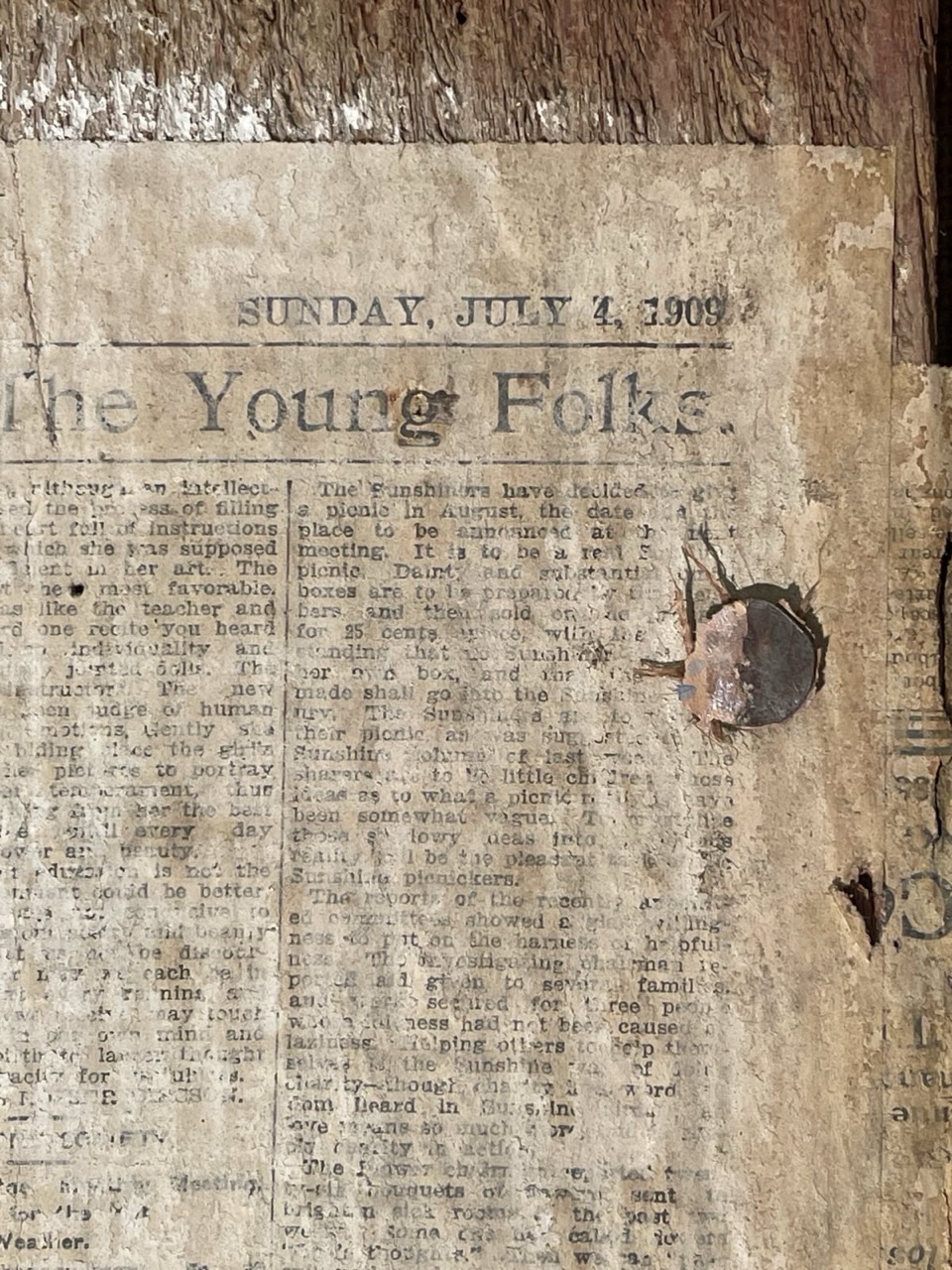 image of a wall with some old newspapers plastered on.