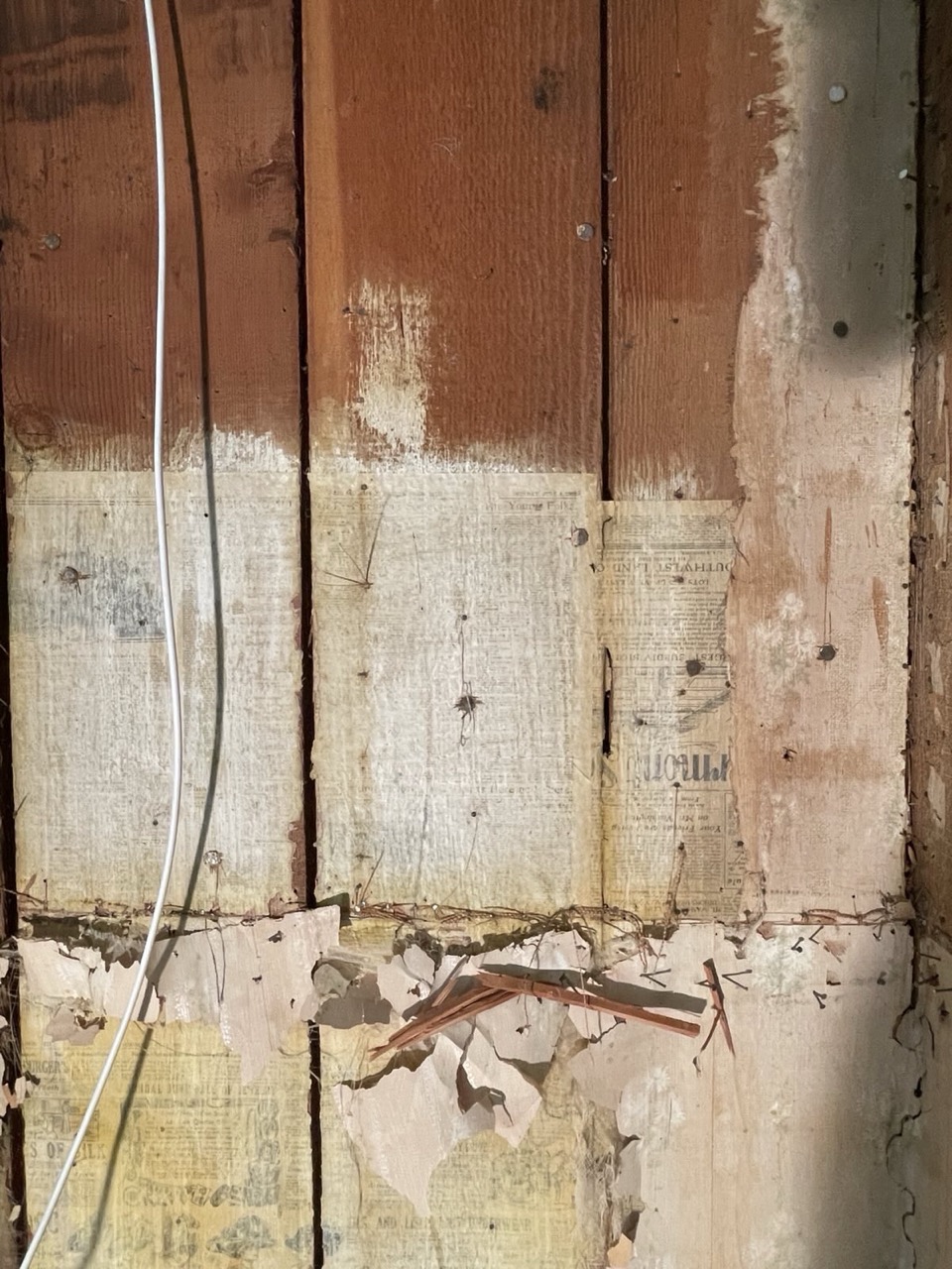 image of a wall with some old newspapers plastered on.