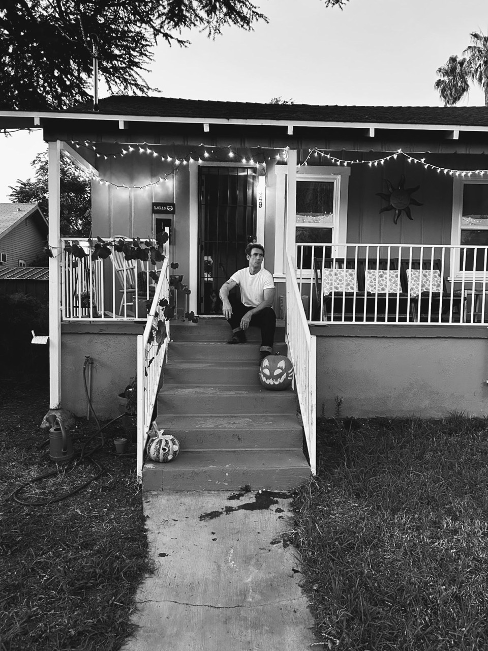 image of nelson at the house with string lights rendered black and white.