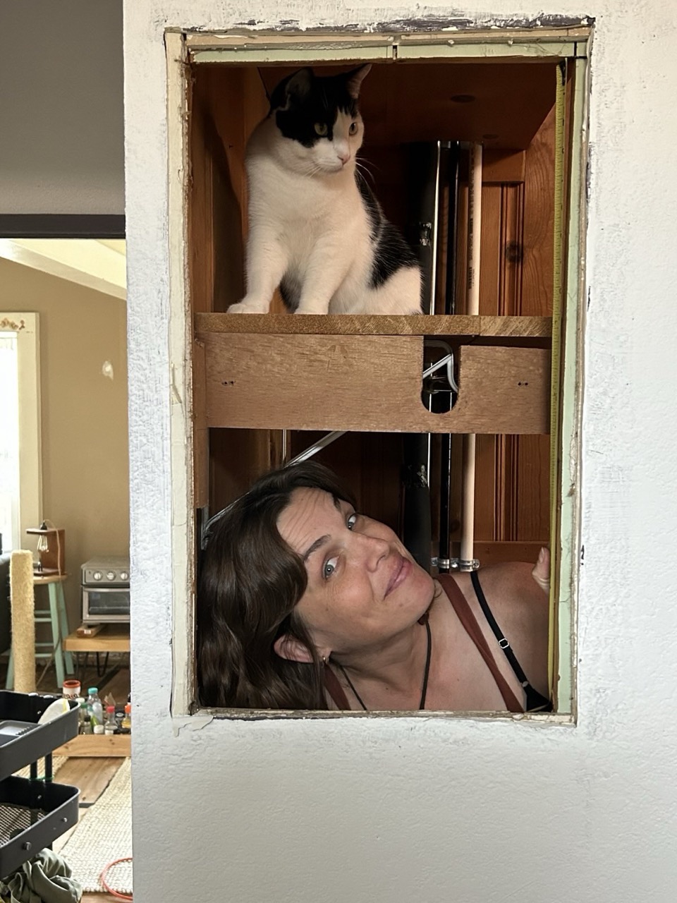 image katie and tiago looking thru a hole in the wall.